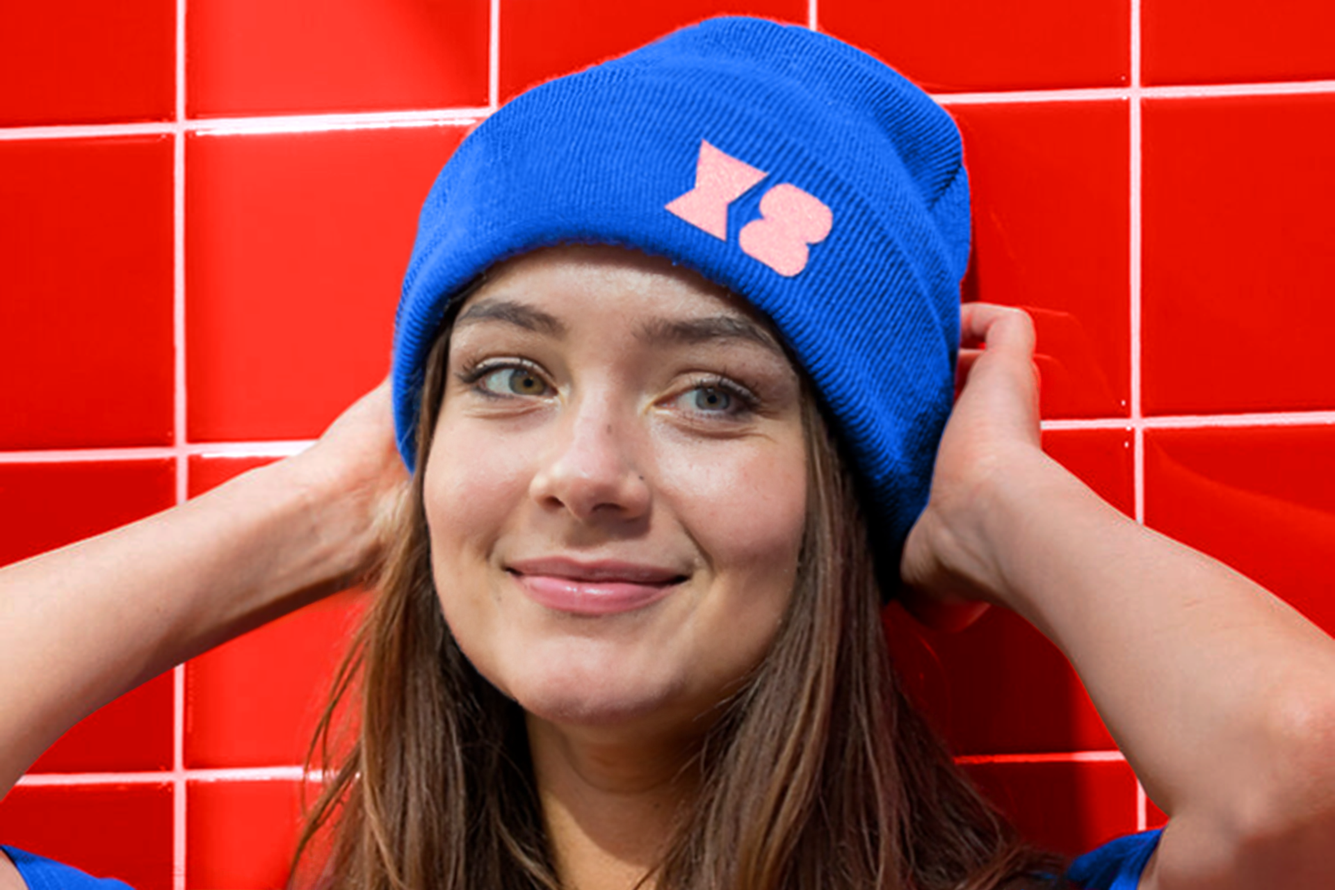 Woman wearing a beanie with the brand symbols embroided